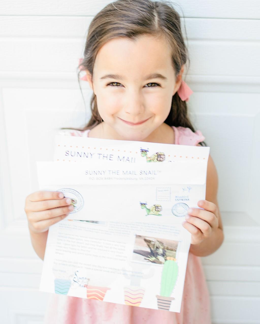 A girl smiling while reading her personalized Sunny letter